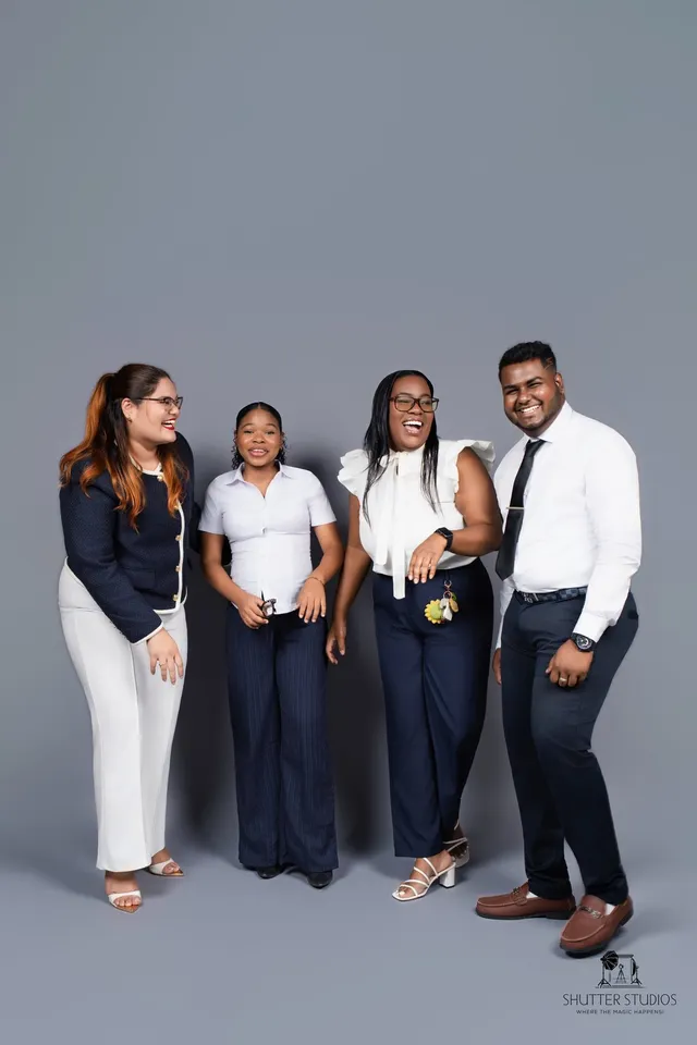 Four OSS staffing team colleagues laughing together in a studio portrait, Georgetown, Guyana
