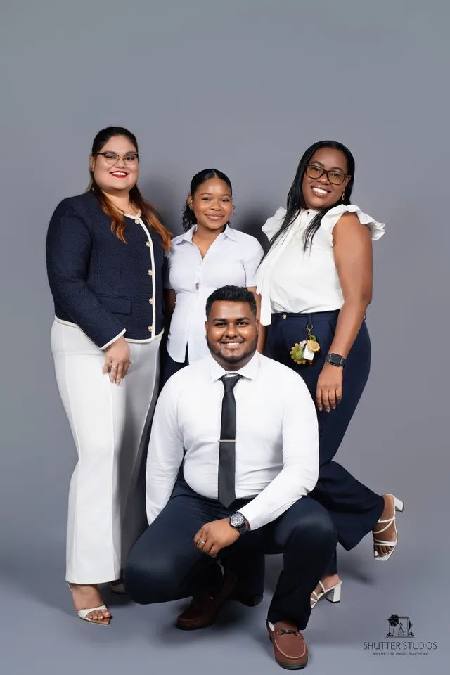 Four OSS staffing team colleagues posing together in a studio portrait, Georgetown, Guyana