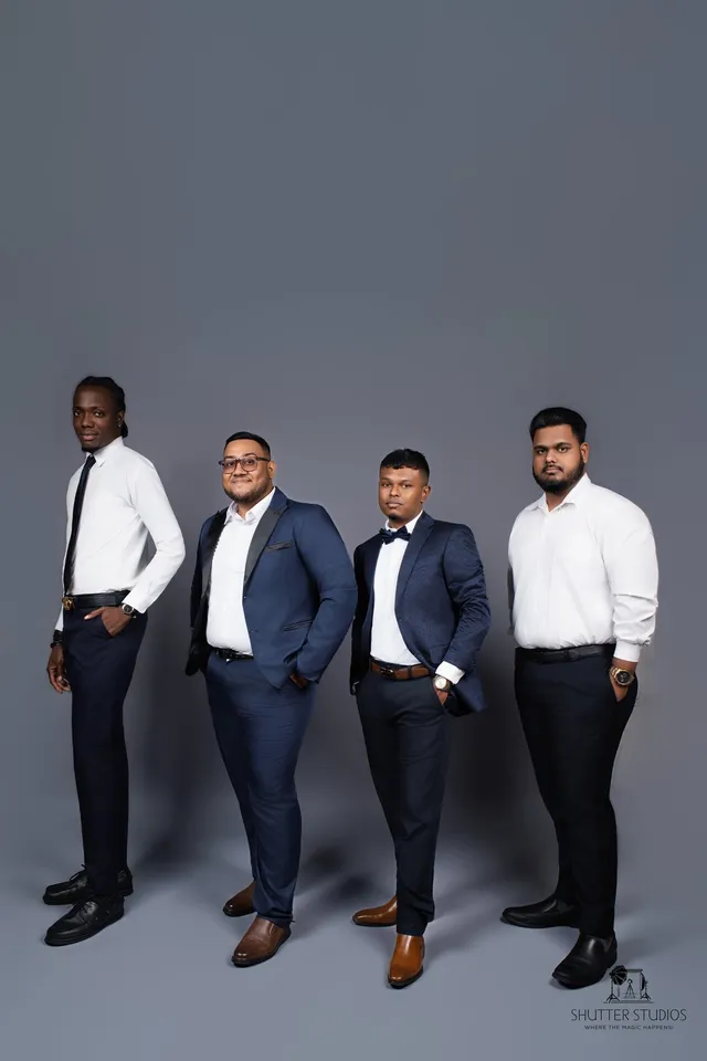 Four OSS staffing team members in business attire, studio portrait, Georgetown, Guyana