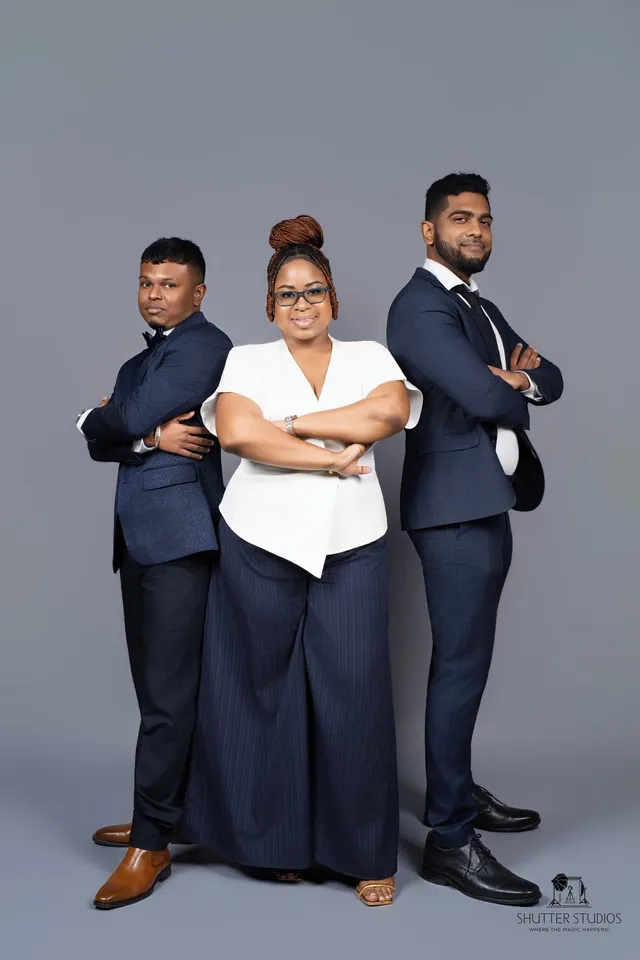 Three OSS staffing team members posing back-to-back in a studio portrait, Georgetown, Guyana